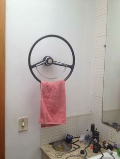 a bathroom with a sink, mirror and towel hanging on the rack in front of it