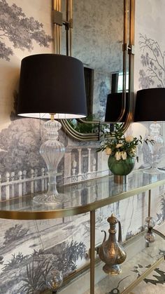 a table with two lamps and a mirror on it