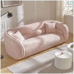 a pink couch sitting on top of a wooden floor