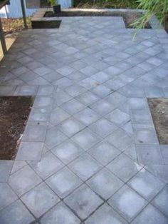 an outdoor patio with concrete pavers and plants