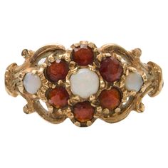 Step into the allure of history with this antique Edwardian 9 karat yellow gold halo ring, hailing from England. Adorned with the mesmerizing hues of opal and the deep richness of garnet, this ring is a testament to timeless beauty and sophisticated craftsmanship. Each stone is carefully set within the halo design, creating a harmonious blend of colors that dance with every movement. The opal, with its iridescent play of color, captures the essence of ethereal beauty, while the garnets add a tou Bohemian Style Rings, Gold Halo Ring, Medieval Rings, Halo Design, Nail Jewelry, Gold Halo, Ethereal Beauty, Halo Ring, Halo Rings