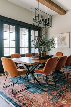 a dining room table with orange chairs and a rug on the floor in front of it