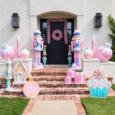 an entrance to a house decorated with pink and blue decorations, including giant candy canes