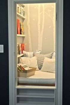 an open door leading into a room with bookshelves and pillows on the shelves