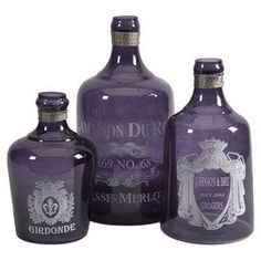 three purple glass bottles sitting next to each other