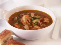 a white bowl filled with soup next to a piece of bread