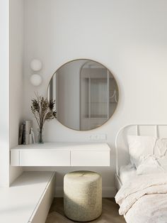 a white bedroom with a round mirror on the wall and a stool in front of it