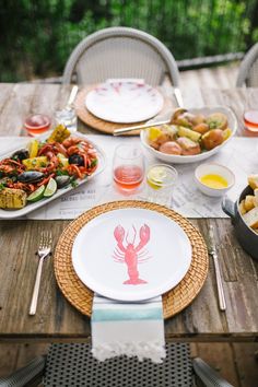 a table set with lobster plates and silverware