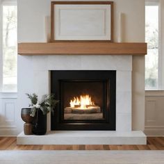 a fire place in the middle of a living room with wood floors and white walls