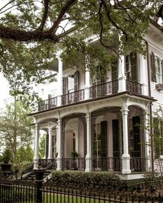 a large white house with lots of windows and balconies