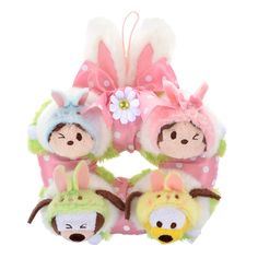 two small stuffed animals are attached to a pink and green wreath with white polka dots