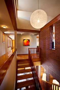 Brick & wood modern prairie style home interior with artistic hanging globe lamp, artworks & wooden floating stairs. Brick Interior Design, Modern Prairie Style, Prairie Modern, Brick Interior