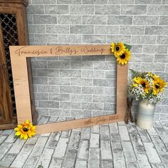 two sunflowers are sitting next to a wooden frame with the word princess and billy's wedding written on it