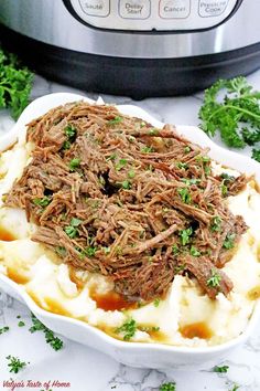 pot roast with mashed potatoes and parsley in front of an instant pressure cooker