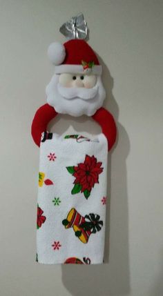 a santa clause towel holder hanging on the wall with a christmas decoration attached to it