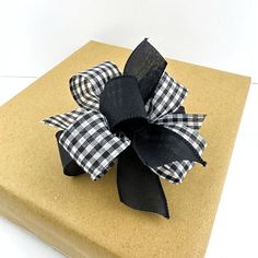 a black and white bow sitting on top of a brown box