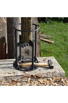 an old fashioned stove sitting on top of a piece of wood next to a tree