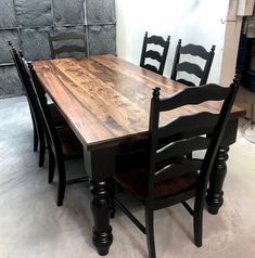 a wooden table with black chairs in a room