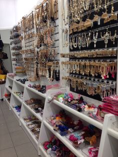 there are many necklaces and bracelets on display in the store's shelving