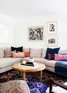 a living room filled with furniture and pictures on the wall above it's coffee table