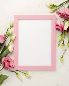 a pink frame surrounded by flowers on a white surface