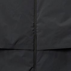 the back of a black jacket with zippers