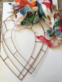 a heart shaped piece of fabric sitting on top of a cutting board