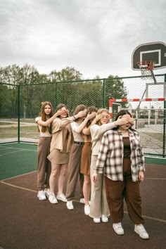 a group of young women standing on top of a basketball court next to each other