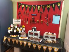 a table topped with lots of desserts next to a red wall