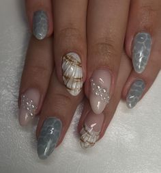 a woman's manicure with seashells and pearls on her nails is shown