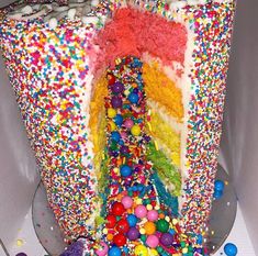 there is a cake that has been decorated with sprinkles and rainbow colors