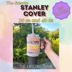 a hand holding a coffee cup with the words stanley cover on it in front of a colorful background