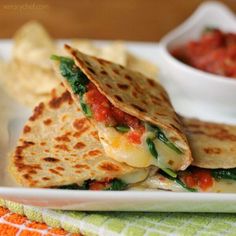 two quesadillas on a plate with salsa and tortilla chips