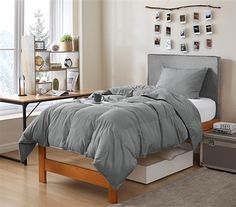 a bed with white sheets and pillows in a bedroom next to a dresser, window