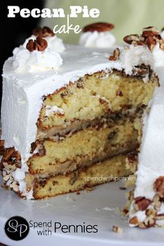 a cake with white frosting and pecans on top