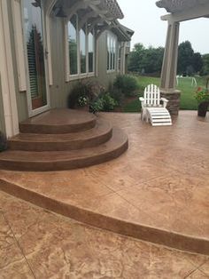 an outdoor patio with steps leading up to the front door