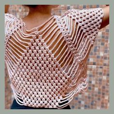 the back of a woman's top that is crocheted