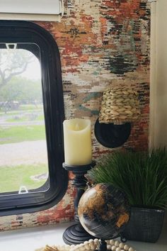 a window sill with a candle and other items on it next to a wall