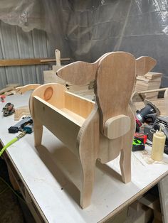 a wooden toy elephant sitting on top of a table next to other toys and tools