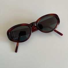 These bold round oval sunglasses are your everyday go to pair.  Featuring a red tortoise frame with smoke lens.  True genuine vintage sunglasses from the 90s.   - 400 uv  - new vintage from the 90s - includes sunglasses pouch  Measurements: Lens width 49mm Lens height 35mm Frame width 133mm Bridge 19mm Arm temple 130mm Also available in amber  https://etsy.me/2XVXRgA Or black https://etsy.me/3F8hUcT Tortoise Shell Sunglasses Women, Affordable Oval Sunglasses With Tinted Lenses, Sunglasses Women Round Face, Dapper Day Outfits, Sunglasses Pouch, Shell Frame, Tortoise Shell Sunglasses, Vintage Sunglasses, Oval Sunglasses