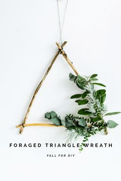 a triangle made out of branches and greenery with the words, foraged triangle wreath