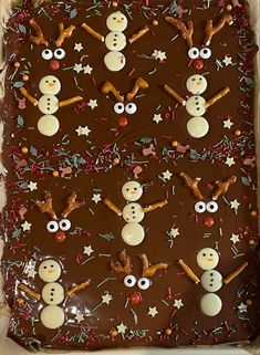 a chocolate sheet cake decorated with frosting and snowman's eyes, noseballs, and stars