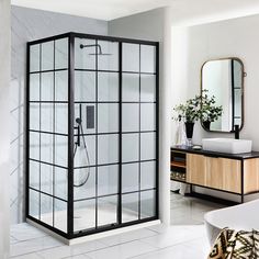 a bathroom with a walk in shower next to a bathtub and sink on top of a white tiled floor