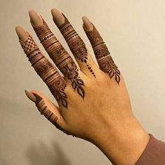 a woman's hand with henna tattoos on it