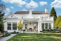 a large white house sitting on top of a lush green field