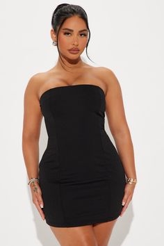 a woman in a black dress posing for the camera with her hands on her hips