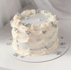 a white frosted cake sitting on top of a table