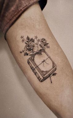 a tattoo on the leg of a woman with flowers and an old tv in it