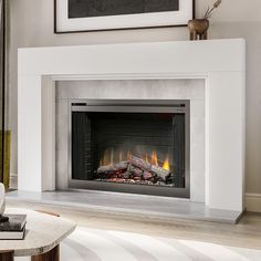 a fire place in a living room with a painting on the wall