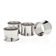 four silver napkin holders on a white background